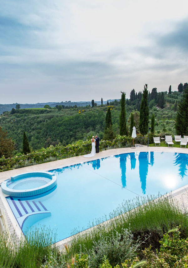 couple admiring the panorama from the swimming pool of a Tuscan Villa