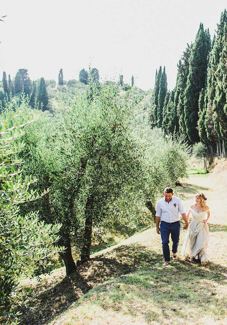 couple walking through the olive trees Tuscany