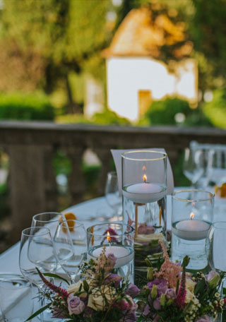 Wedding table on the terrace of a Tuscan Villa overlooking a garden with a chapel 